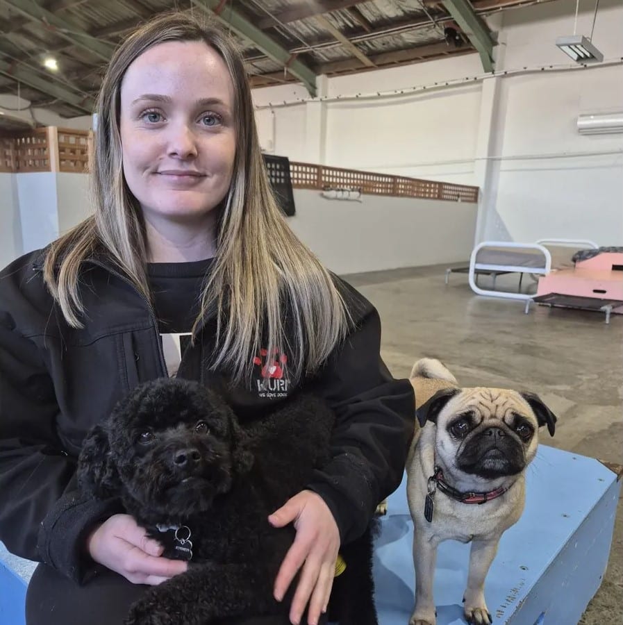 Becky with a dog on her lap and a pug beside her. About us.